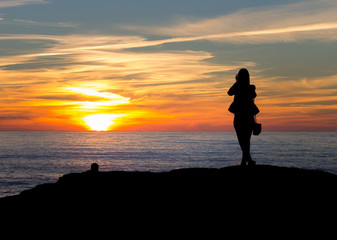 Silhouetted Woman Takes Photo of the Sunset