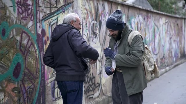 beggar alone  in the street receive alms by an old man-help, generosity
