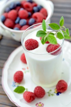 Yogurt with fresh berries on dark background