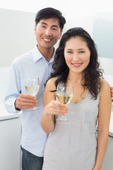 Loving young couple with wine glasses in kitchen