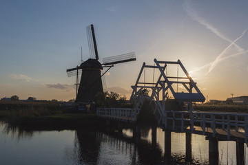 Sunset on windmill reflected in the canal Kinderdijk Molenwaard South Holland The Netherlands Europe