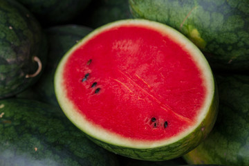 Many big sweet green watermelons and one cut watermelon