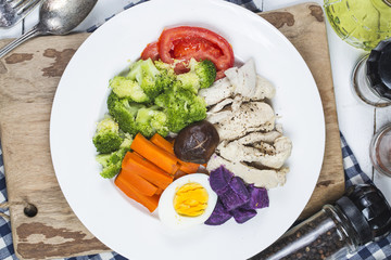 Boiled chicken breasts and vegetables with sports and diet concepts.