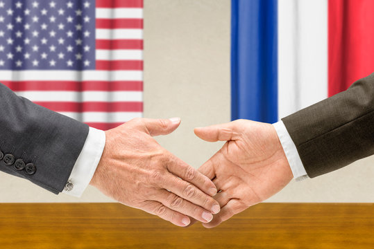 Vertreter der USA und Frankreichs reichen sich die Hand