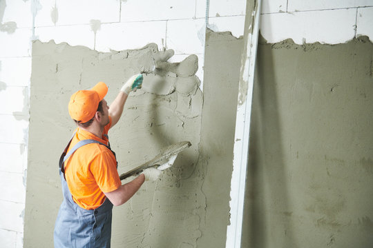 Plasterer Spreading Plaster On Wall. Renovation Service