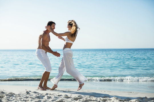 Side view of playful couple at beach