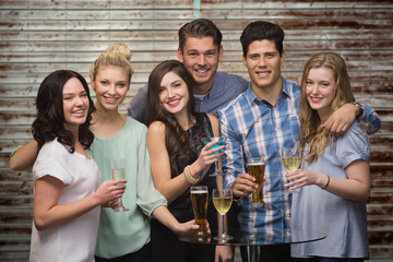 Friends with drinks against wooden planks