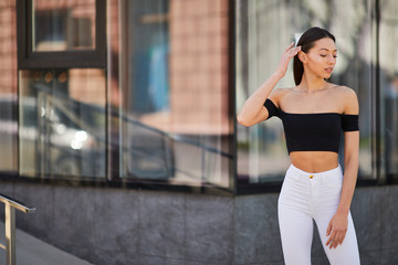 Beautiful sporty girl posing to camera on the street, spring time photo shoot