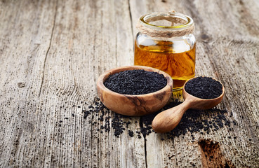 Black cumin oil on wooden background