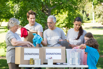 Happy volunteer family separating donations stuffs