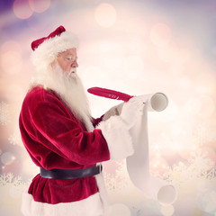 Father Christmas writes a list against glowing christmas background