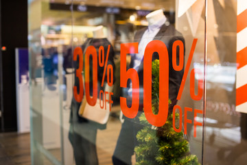 Shopping sale sign. Sign of sale shopping.discount sign on show window. Sale sign, symbol in clothes shop,The red announcement of a fifty-percentage discount on a glass show-window. Copy space - obrazy, fototapety, plakaty