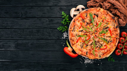 Pizza with chicken and mushrooms. Top view. On a wooden background. Copy space.