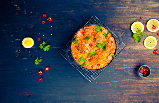Creamy South Indian style Roast Chocken Curry on black pot on dark blue wooden rustic table