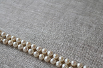beads made from artificial pearls on gray linen fabric

