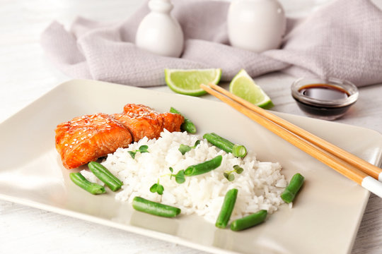 Fish fillet served with rice and green beans on wooden background