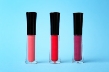 Obraz premium Beautiful lip glosses on color background