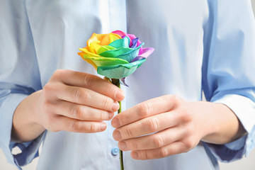 Woman holding rainbow rose flower, closeup
