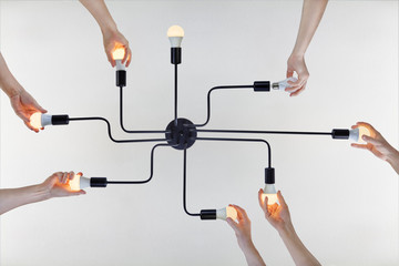 Colleagues working out together for install led bulb  in lampholder.