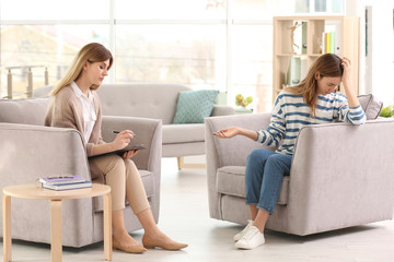 Young female psychologist working with teenage girl in office