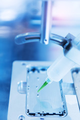 Robot holding glue syringe Injection in mobile phone factory