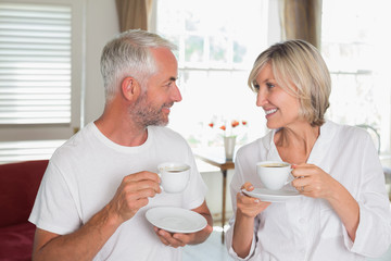 Couple with coffee cups looking at each other