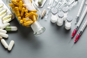 Different medications as a pills, tablets and injections on gray background