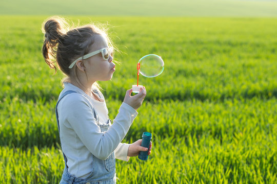 little girl is blowing a soap bubbles, Outdoor Portrait