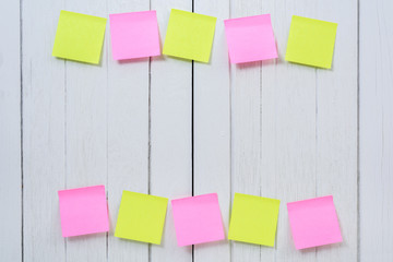 Many colorful sticky note, post note on white wooden vintage background