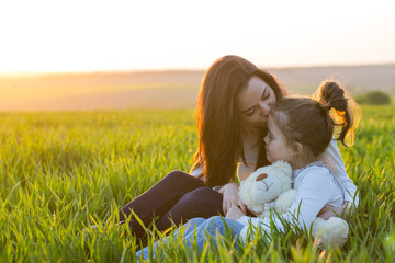 mother and daughter hugging in love playing in the park