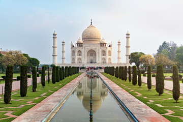 Taj Mahal front view reflected on the reflection pool, an ivory-white marble mausoleum on the south...