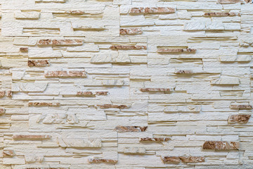 Wall made of decorative light brown stone. Decorating for the fireplace. Background