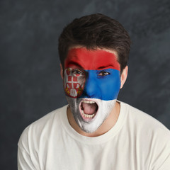 Young man with Serbia flag painted on his face