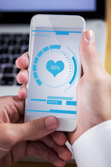 Businessman using smartphone against fitness interface