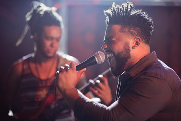 Male singer performing on stage at nightclub - obrazy, fototapety, plakaty