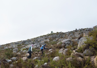 Couple walking through rocky landscape against clear sky