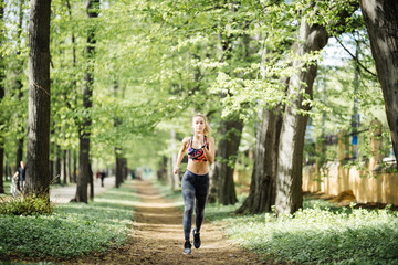 Fototapeta na wymiar Runner athlete running at cityl park. Young woman fitness jogging workout wellness concept.