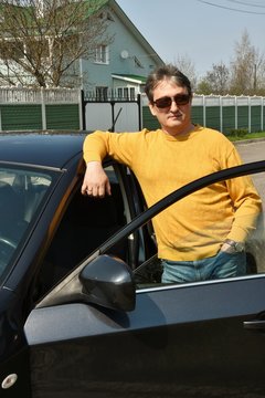 a man is standing by the car