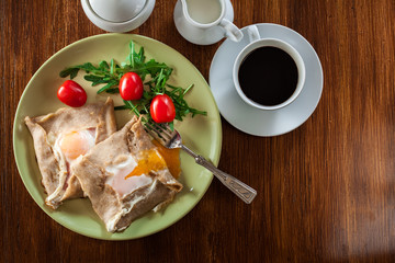 Crepes with ham, cheese and poached egg on a plate