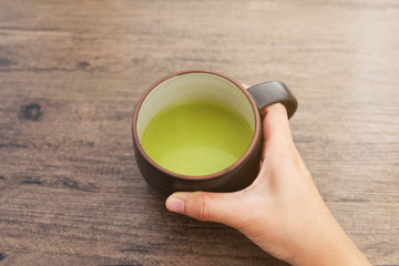 Cup of Matcha Green Tea in hand