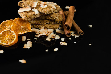 Fototapeta na wymiar Granola bars with dried coconut, cinnamon sticks and orange slices