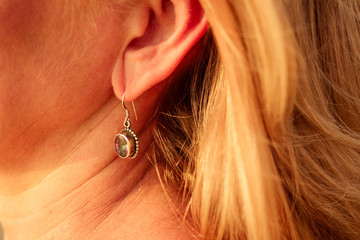 ear of a happy woman with a beautiful earring