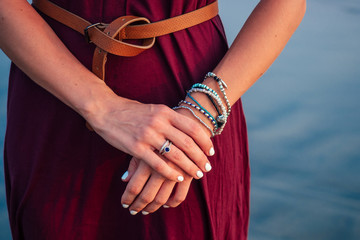 beautiful and well-groomed hands with a natural manicure with chic and elegant bracelets