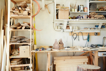 Workbench of carpenter with assortment of wooden workpieces, toolbox and other equipment