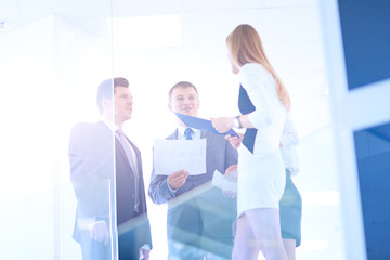 Portrait of young businessman in office with colleagues in the background . Portrait of young businessman.