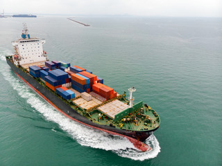 Cargo container ship carrying container import and export  goods running around container yard port concept freight shipping ship.