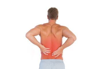 Shirtless man suffering from lower back pain on white background