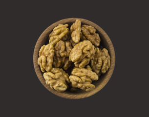 Kernels walnuts isolated on black. Walnuts in a bowl isolated on black background. Top view. Walnuts with copy space for text on black background
