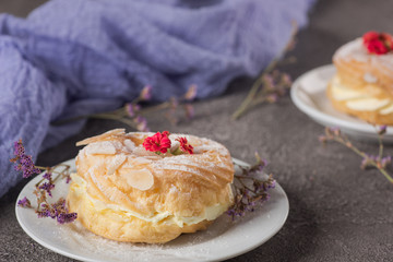 Delicious cake with cream on a plate. Concrete rustic background. Top view
