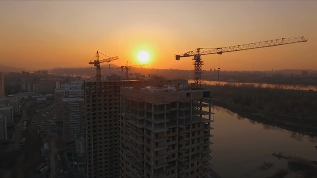 Aerial view shot of the sunset on the construction of a new district on the Bank of the Yenisei river. Krasnoyarsk, Russia.